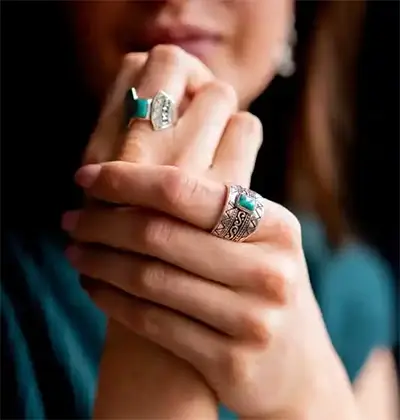 Model draagt zilveren ringen met turkoois steen,